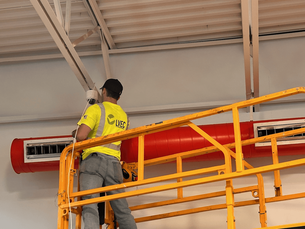LVEC technician on a scissor lift installing a dome camera