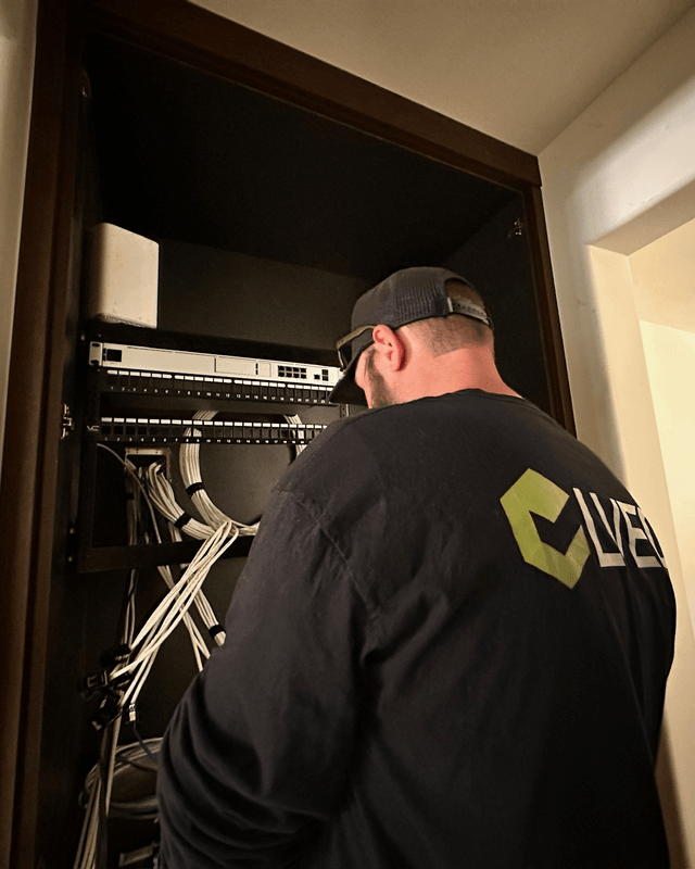 LVEC technician terminating cables in a network rack